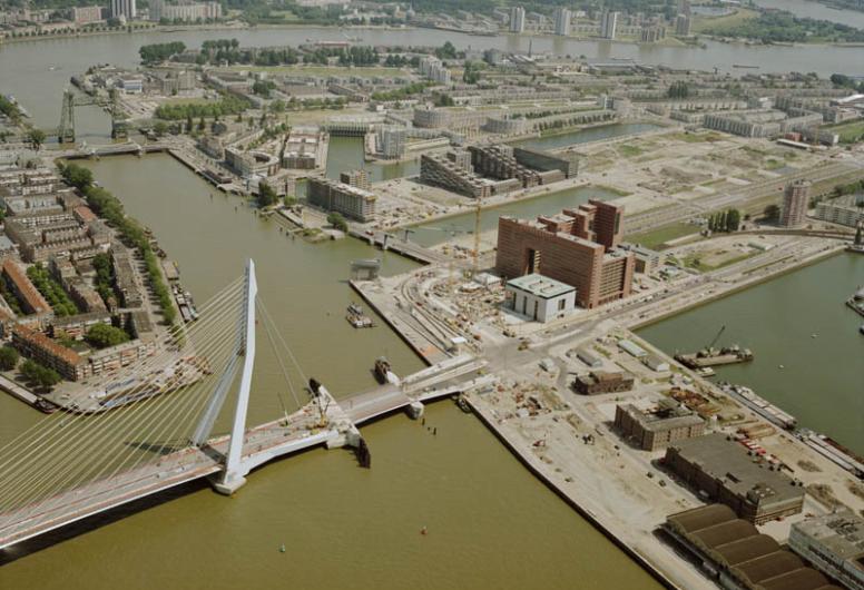 Luchtfoto met een overzicht van de Erasmusbrug, het Noordereiland en de Kop van Zuid, gezien vanuit het westen.