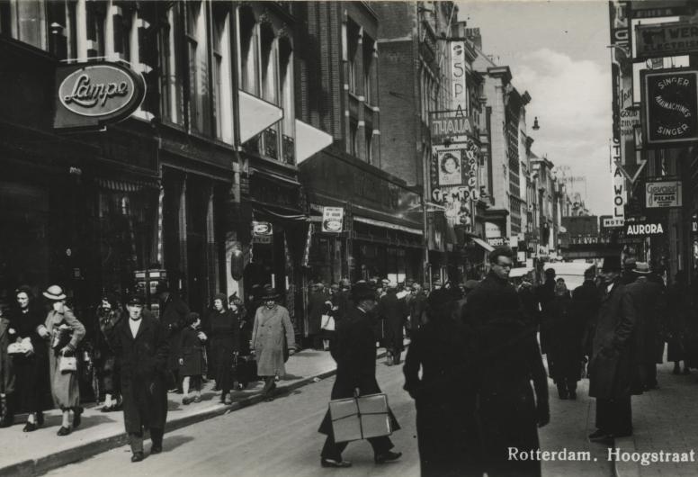 Hoogstraat bij de Wijde Kerksteeg, vanuit het westen, tussen Spui en Vlasmarkt. Op de voorgevel van bioscoop Thalia reclame voor een film van Shirley Temple, 1939.
