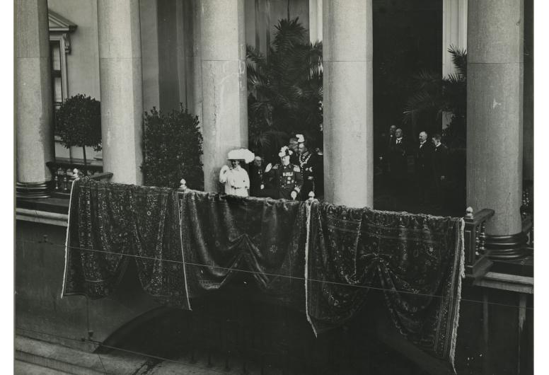 Koningin Wilhelmina en prins Hendrik op de balustrade van het stadhuis aan de Kaasmarkt tijdens hun bezoek aan Rotterdam. Collectie 4282, XXXIII-264-1