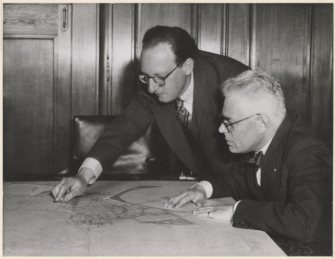 Ingenieur W.G. Witteveen (links) aan wie de opbouw van de nieuwe binnenstad is opgedragen, geeft burgemeester P.J. Oud een toelichting, juni 1940. Collectie 4202, XXXIII-574-01-2. Fotograaf E.A. Hof