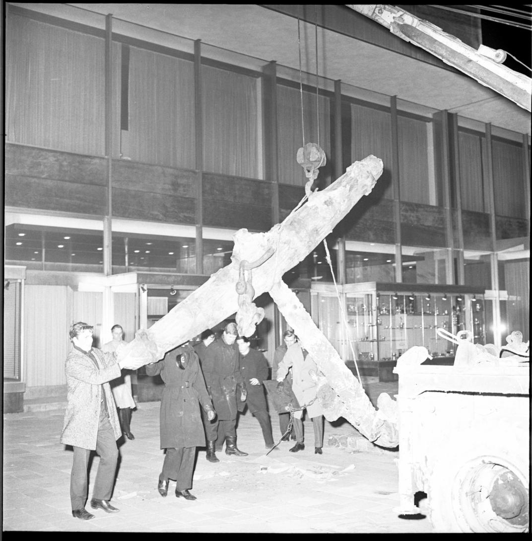 Zwart-wit foto van leerlingen die een anker verplaatsen. 