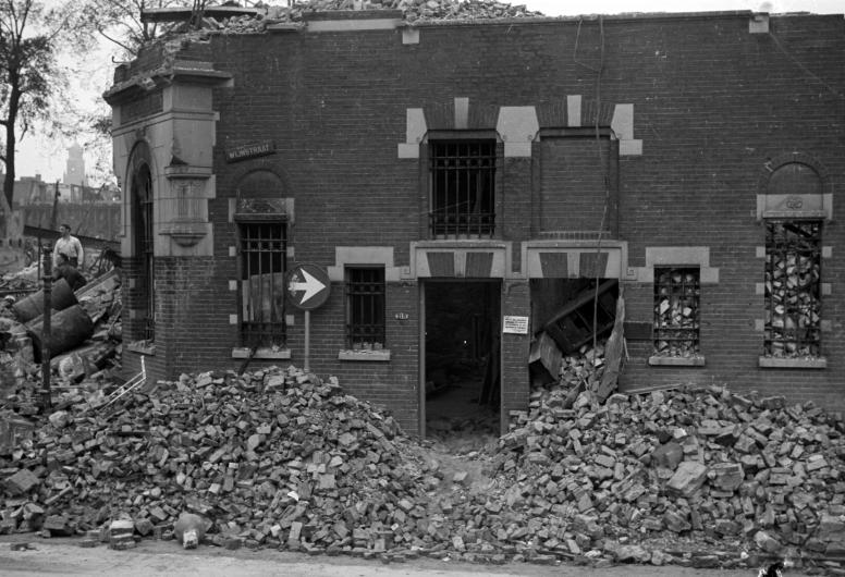 De gevel van de achterzijde van de Bank voor Handel en Scheepvaart aan de kant van de Wijnstraat omgeven door puin. Collectie 4156, nummer 5007