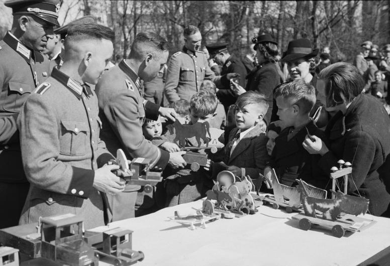 Duitse soldaten delen speelgoed uit.