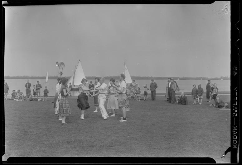 Op Koninginnedag dansen jongeren in het Kralingse Bos bij de Boszoom, 1955. Fotograaf Cock Tholens. Collectie 4117 THO-311.
