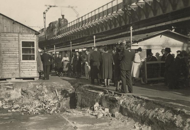 Mannen, vrouwen en kinderen wandelen tussen de houten keten die opgesteld zijn aan weerszijden van de Binnenrotte