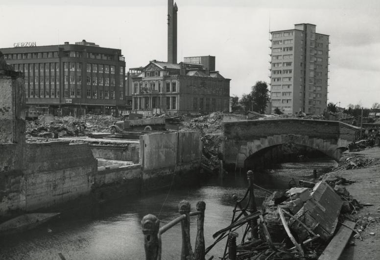 De door het bombardement van 14 mei 1940 getroffen Steigersgracht met de Weezenbrug. Van links naar rechts warenhuis Gerzon, het Schielandshuis en het Erasmushuis, juni 1940. NL-RtSA_4135_XXXIII-569-39-9