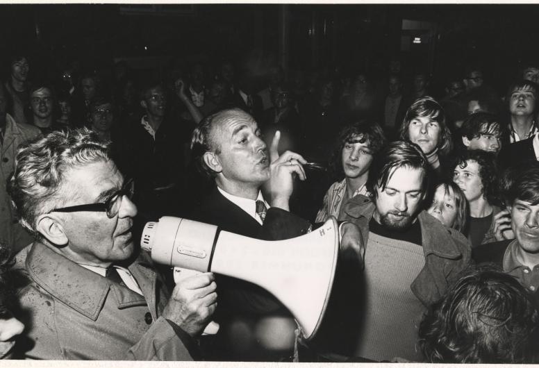 11 augustus 1972: Burgemeester Thomassen bezoekt de Afrikaanderwijk na de rellen tussen bewoners. In augustus ontaardde een huurconflict tussen een Turkse verhuurder en een Nederlandse huurder in de Afrikaanderwijk in Rotterdam-Zuid in een soort volkswoede. Vechtpartijen breken uit en bezittingen van de Turkse bewoners worden vernield. Dagenlang zijn de gemoederen verhit, ondanks de aanwezigheid van oproerpolitie en burgemeester Thomassen die de bewoners probeert te kalmeren. Fotograaf: Peter Molkenboer. Co
