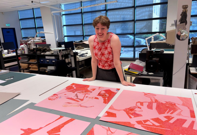 Minne Ponsen staat voor een grote tafel met haar tekeningen op tafel