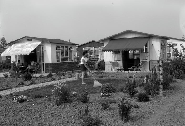 Een vrouw harkt haar tuin in volkstuinencomplex De Beukhoeve aan de Slinge, 1959. Foto: Fototechnische Dienst Gemeentewerken Rotterdam, collectie 4273, nummer L-4329