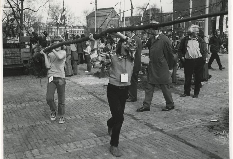 Zwart-witfoto van 2 kinderen die een  boom dragen tijdens boomplantdag 1974.