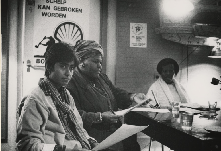 Zwart wit foto van drie vrouwen van kleur bij een discussie