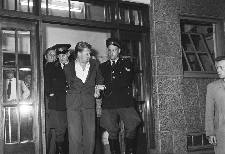 Hans Gruijters, alias de "Zwarte Ruiter", wordt weggevoerd door de Rijkspolitie bij het hoofdbureau van politie aan het Haagseveer. 