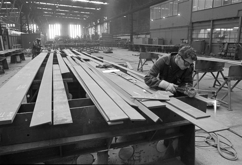 In één van de scheepsbouwloodsen van de RDM is een lasser aan het werk.