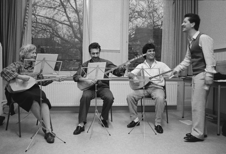 Leerlingen van de muziekschool van de Stichting Kunstzinnige Vorming Rotterdam (SKVR) krijgen sazles. Rechts staat de docent.