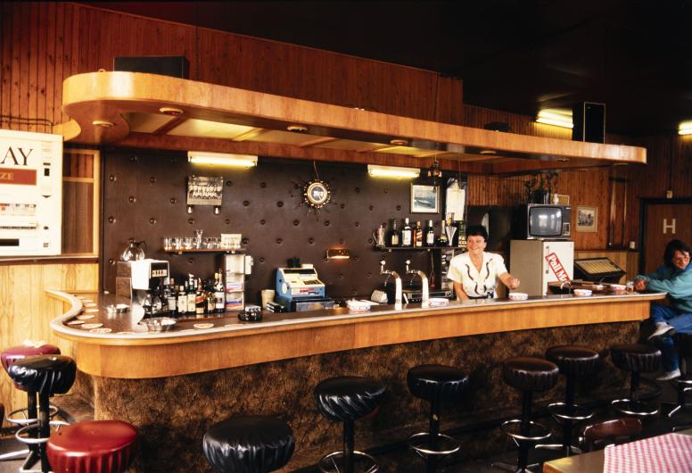 De bar en barvrouw van café 'De Vergulde Zwaan' op de hoek van de Mathenesserdijk en de Schiedamseweg. 23 mei 1987