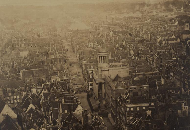 Zicht vanaf de Laurenstoren op het oostelijk deel van de binnenstad. In het midden is de Kaasmarkt met het stadhuis te zien. Onder de koepel naast de toren bevindt zich de Rotondezaal. Collectie Vroege foto's. NL-RtSA_4187_RI-248a