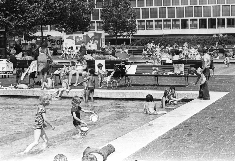 Spelende kinderen het pierenbad op het Schouwburgplein. Op de achtergrond De Doelen. 1980