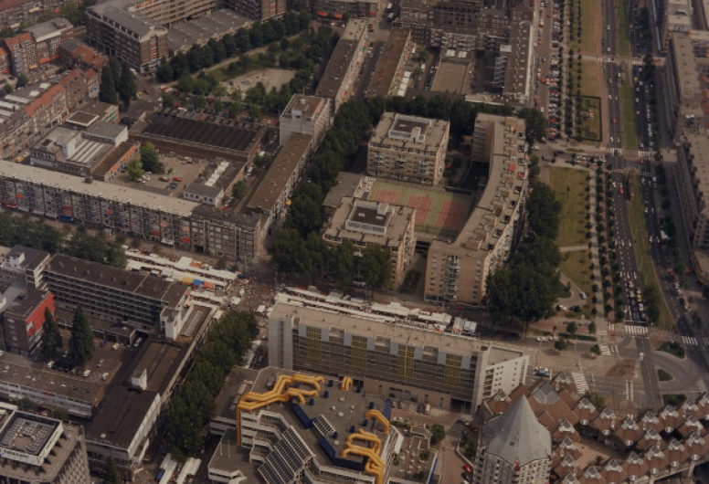 1991-1658: Luchtopname van de omgeving van de Hoogstraat (links), in het midden gekruist door de Mariniersweg. Op de voorgrond de Centrale Bibliotheek, de Blaaktoren (het Potlood), en de Kubuswoningen, en geheel vooraan werkzaamheden voor de aanleg van de