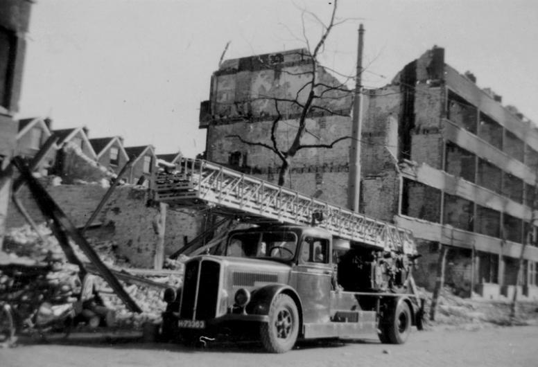 Gezicht op de door het geallieerde bombardement getrofffen Mathenesserweg met verwoeste huizen en gebouwen als gevolg van het bombardement is een deel van westelijk Rotterdam rondom de Schiedamseweg grotendeels verwoest. Met ladderauto bij blussingswerk, 31 maart 1943. Anonieme foto. Collectie 4287, nr. XXXIII-632-00-01-19