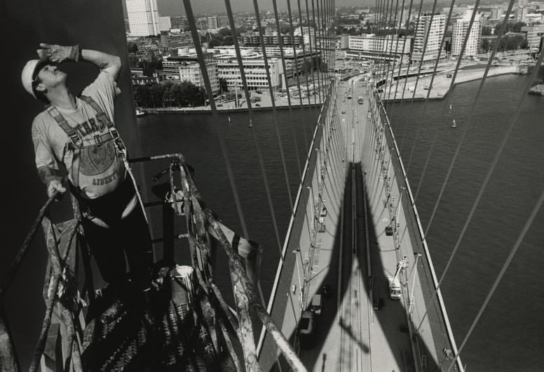 Een schilder bij de pyloon van de Erasmusbrug in aanbouw. Op de achtergrond de brug in noordelijke richting en de Rechter Maasoever. 1996. NL-RtSA_4110_1996-2300