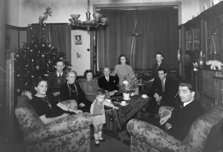 Onbekende familie in de woonkamer bij de kerstboom. F.H. van Dijk. December 1945. Collectie 4117. Documentnummer 1976-4718