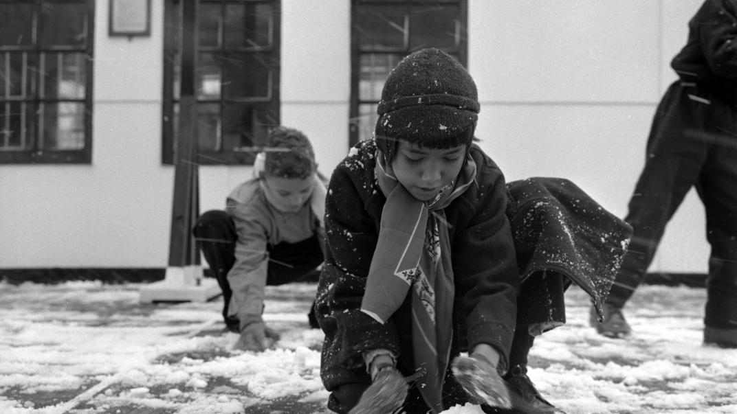 Met de Sibajak uit Indonesie aangekomen kinderen maken op de Lloydkade kennis met sneeuw (1958). Fotograaf Ary Groeneveld, collectie 4121, nummer 1192-4-01