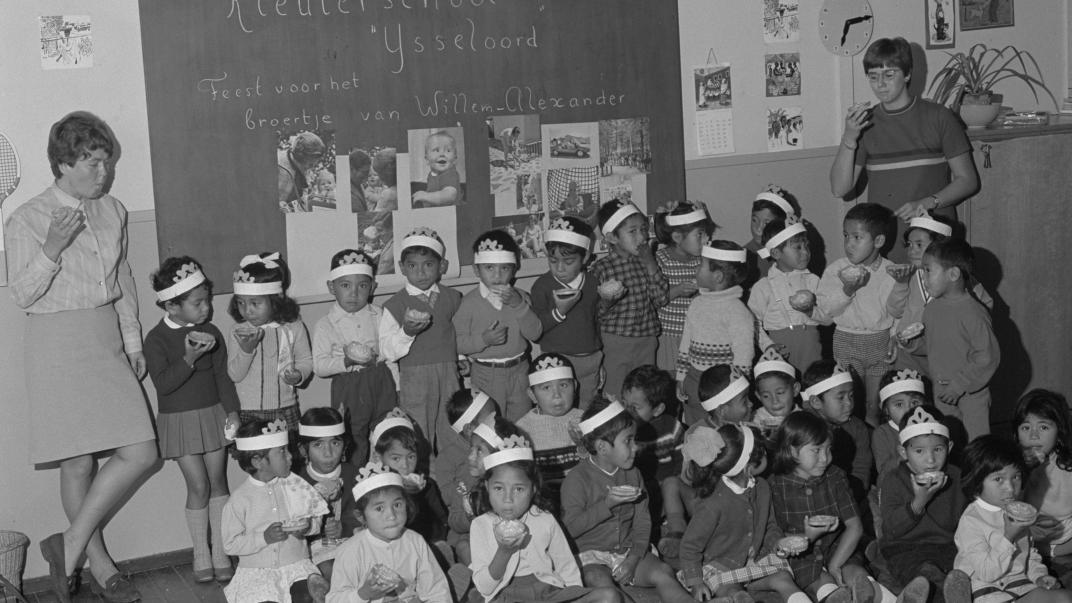 Molukse kinderen met hun begeleidsters in de kleuterschool op het barakkenkamp IJsseloord (1968). Fotograaf Ary Groeneveld, collectie 4121, nummer 11225-01