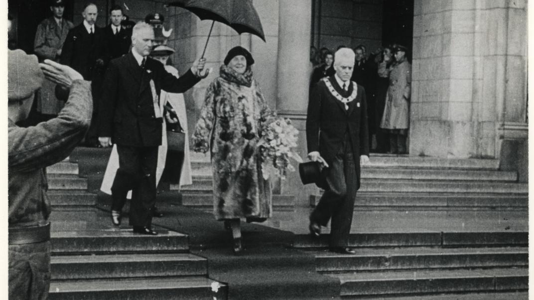 Het eerste bezoek na de bevrijding van koningin Wilhelmina aan Rotterdam. Koningin Wilhelmina verlaat met burgemeester Oud het stadhuis. Collectie 4282, 1975-498. Fotograaf Polygoonjournaal